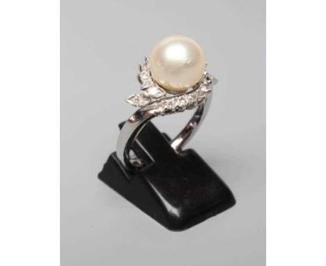 A PEARL AND DIAMOND COCKTAIL RING, the cultured pearl set to a swirl border of small diamonds to a white shank stamped 18K, s