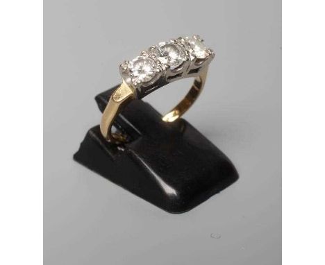 A THREE STONE DIAMOND RING, the round brilliant cut stones each of approximately 0.3cts, claw set to a plain 18ct gold shank,
