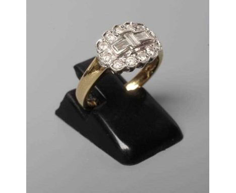 AN ART DECO DIAMOND RING, the three baguette cut stones collet set to a border of twelve brilliant cut stones point set to a 