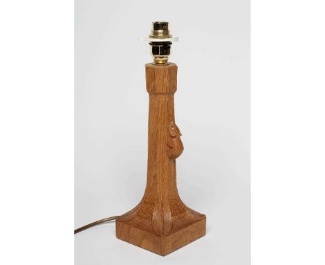 A ROBERT THOMPSON ADZED OAK TABLE LAMP of candlestick form, the faceted tapering stem with carved mouse trademark in high rel