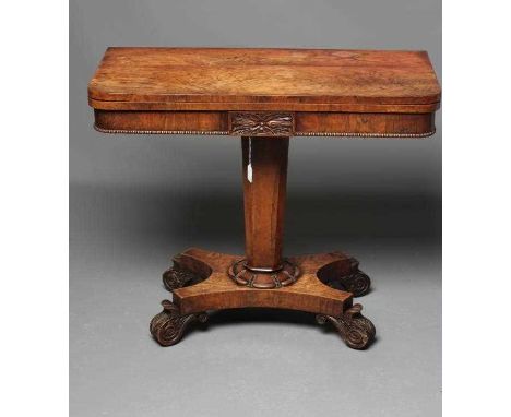 A REGENCY ROSEWOOD FOLDING CARD TABLE, early 19th century, the rounded oblong swivel top opening to a shaped red baize, bead 
