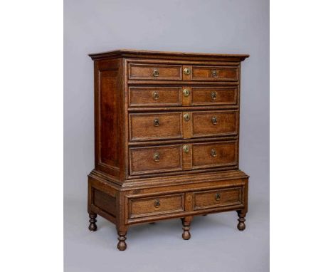 A JOINED OAK CHEST ON STAND, late 17th century, the four graduated drawers with moulded panel fronts and brass drop handles, 