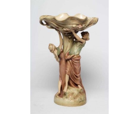 A ROYAL DUX PORCELAIN ART NOUVEAU FIGURAL CENTREPIECE modelled as two young maidens holding aloft a flower moulded shallow di