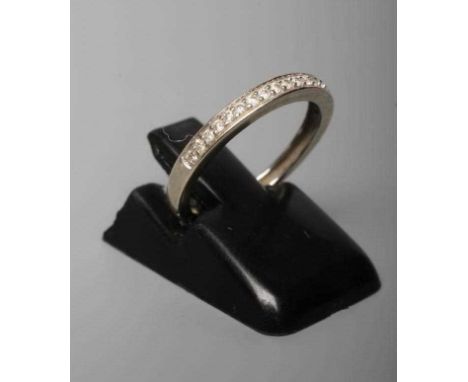 A DIAMOND HALF HOOP ETERNITY RING, the nineteen small brilliant cut stones pave set to a plain 9ct white gold shank, London n