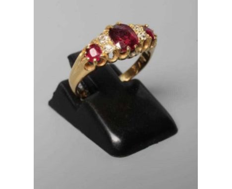 A LATE VICTORIAN RUBY AND DIAMOND RING, the three oval facet cut stones claw set with two pairs of small old brilliant cut di