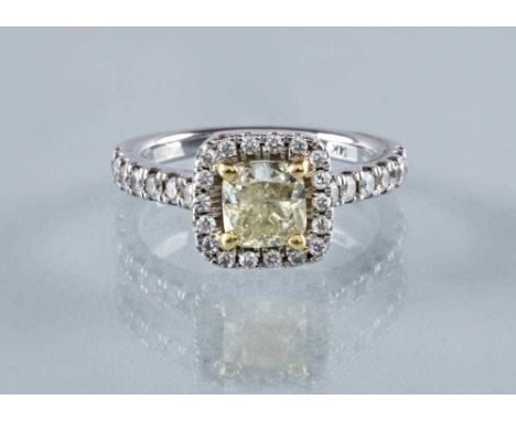 A DIAMOND CLUSTER RING, the cushion cut central Natural LIght Yellow stone of 1.03cts, claw set to a border of eighteen small