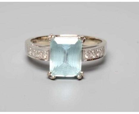 AN AQUAMARINE AND DIAMOND COCKTAIL RING, the step cut aquamarine claw set to plain shoulders each point set with four small r