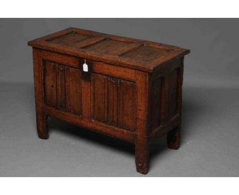 A SMALL OAK PANELLED COFFER, the hinged lid opening to interior with till box, the fascia with a pair of linen fold panels, o