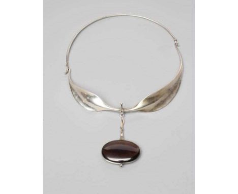 A GEORG JENSEN SILVER NECK RING designed by Viviana Torun Bulow-Hube, the tension clamp extending to two stylised leaf panels