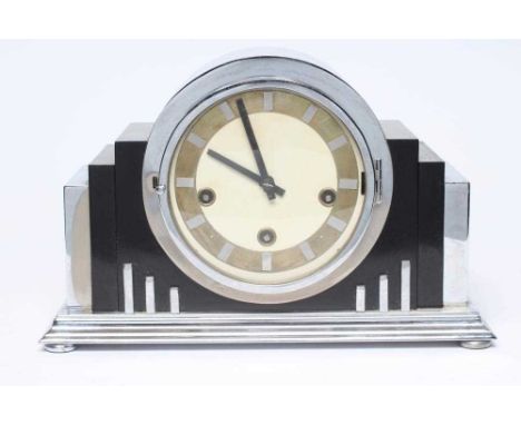 AN ART DECO CHROME CASED CHIMING MANTEL CLOCK, the three train movement striking the half hour on five gongs, 5 1/2" white en