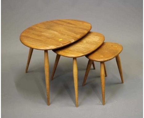 AN ERCOL NEST OF THREE PEBBLE TABLES, Model No.354, with elm top and beech legs, largest 19 3/4" wide (Est. plus 24% premium 