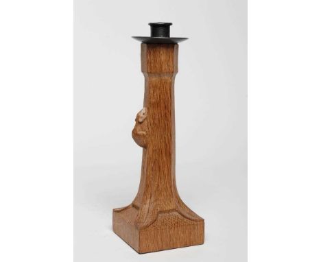 A ROBERT THOMPSON ADZED OAK CANDLESTICK, the turned wrought iron nozzle on faceted tapering stem with carved mouse trademark 