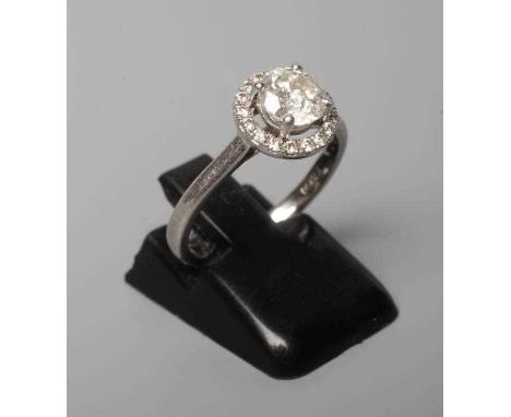 A DIAMOND CLUSTER RING, the central brilliant cut stone of approximately 0.80cts claw set to an open border of numerous point