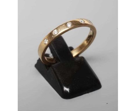 A DIAMOND SET WEDDING RING, the plain 9ct gold band gypsy set with six brilliant cut stones, Birmingham no date letter, spons