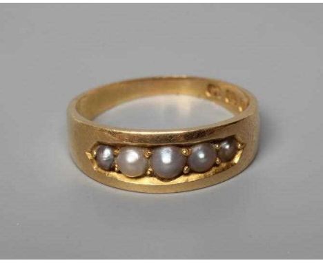A VICTORIAN 18CT GOLD RING, point set with five graduated seed pearls in a boat panel to a plain wide shank, Birmingham no da