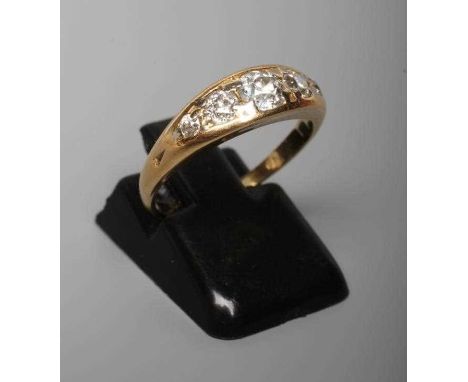 A FIVE STONE DIAMOND RING, the point set graduated stones totalling approximately 0.78cts, in a boat shaped panel to a plain 