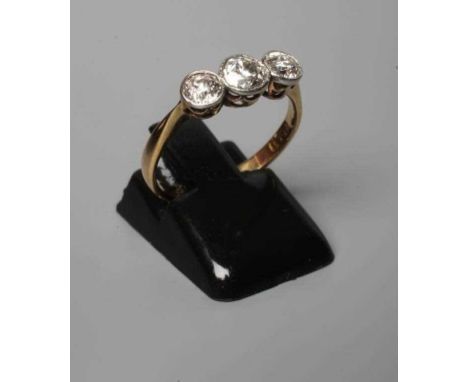 A THREE STONE DIAMOND RING, the old cut stones collet set to a plain shank stamped 18ct, size N (Est. plus 24% premium inc. V