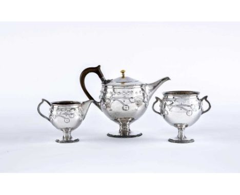 AN EDWARDIAN ARTS AND CRAFTS SILVER THREE PIECE TEA SERVICE, by A E Jones, Birmingham 1910 (sugar) and 1911, of planished glo