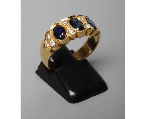 A SAPPHIRE AND DIAMOND DRESS RING, the three oval facet cut sapphires collet set with two pairs of diamonds between and with 