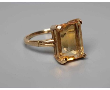 A CITRINE COCKTAIL RING, the rectangular cut stone claw set to reeded shoulders and a plain shank stamped 14K, size L 1/2 (Es