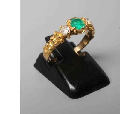 AN EMERALD AND DIAMOND RING, the central facet cut emerald claw set and flanked by two old cut diamonds to reed and husk shou