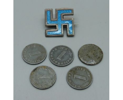 A silver and enamel good luck emblem and five coins 