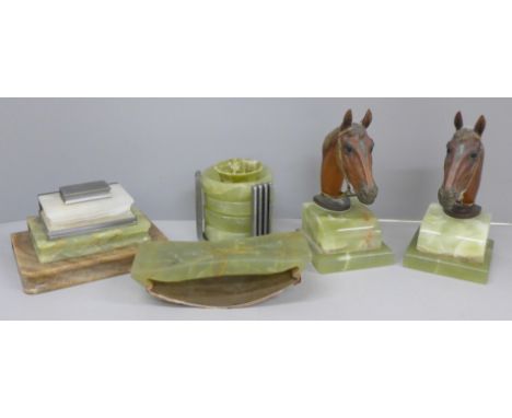 A pair of cold painted bronze horses head bookends on an onyx plinth, an inkstand in the form of books, a blotter and four de