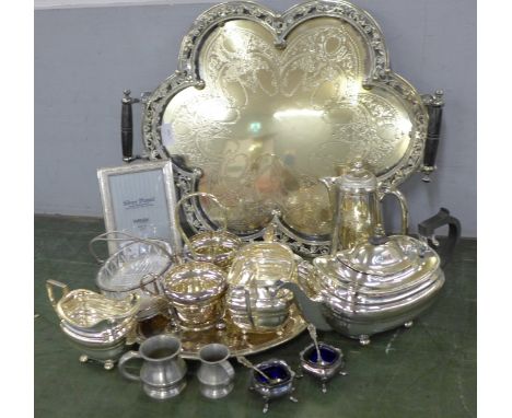A collection of silver plated ware, including a large decorative two handled tray, a coffee pot, tea service, pewter measures