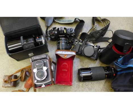 A collection of camera equipment - Yashica-mat 120 twin lens reflex, Canon A1 35mm camera and case, AE1 camera, two Canon len