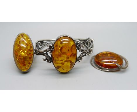 A silver bangle, a silver ring and a silver brooch, set with amber, ring size O 