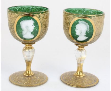 Pair of late C19th Bohemian small green and gilt wine glasses, front panels decorated in white enamel with classical busts, H