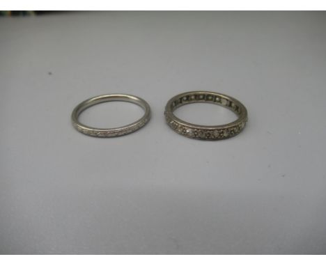 White metal eternity ring set with diamonds, no visible hallmark, size S, and a platinum band with engraved detail, stamped P