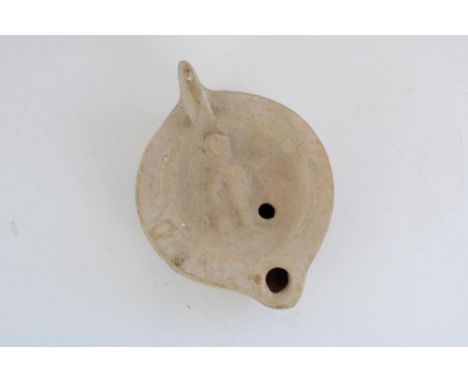 Ancient Cypriot Greco-Roman terracotta oil lamp, central well decorated in relief with a Cherub, 10cm x 8cmProvenance - From 
