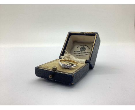 A Dainty Three Stone Diamond Ring, claw set, stamped "18ct&amp;Plat" (finger size M) (weight 1.6grams) in a vintage ring box.