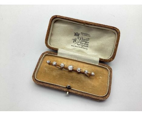 A Seven Stone Diamond Set Bar Brooch, graduated claw set with old cut stones, on knife edge bar, overall length 4.7cm, in vin