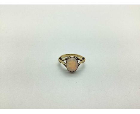 An Opal Set Dress Ring, cabochon set between trifurcated shoulders, stamped "18ct" (finger size L) (2.8grams).