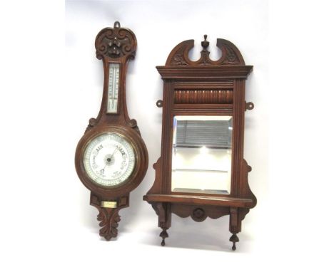 AN EDWARDIAN CARVED OAK ANEROID BAROMETER/THERMOMETER; together with a carved walnut mirrored shelf bracket