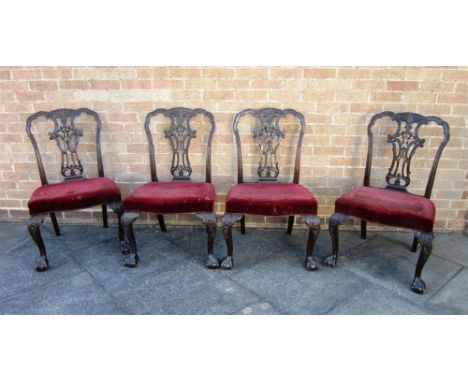 A SET OF FOUR CARVED MAHOGANY DINING CHAIRS in the Chippendale taste, with carved & pierced vase shaped splat backs, overstuf