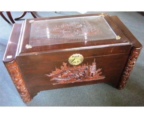 A CAMPHOR WOOD TRUNK With carved decoration depicting figures in a landscape, 101cm wide, 54cm deep, 56cm high