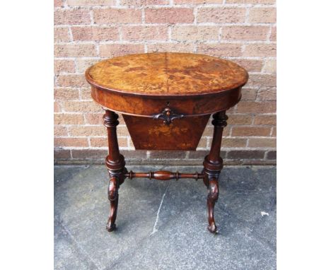 A VICTORIAN BURR WALNUT WORK TABLE With foliate marquetry decoration, the oval top 62cm x 45cm, part fitted interior, carved 