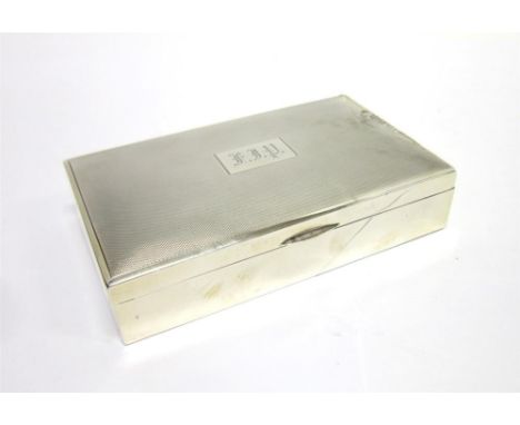 A SILVER CIGARETTE BOX London 1932, engine turned decorated with monogrammed cartouche, 17cm long; with another similar silve