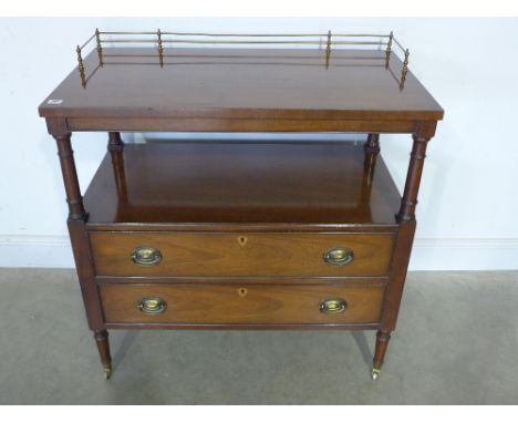 A mahogany buffet -  brass gallery over top tier with shelf below over two long drawers, raised on turned supports with caste