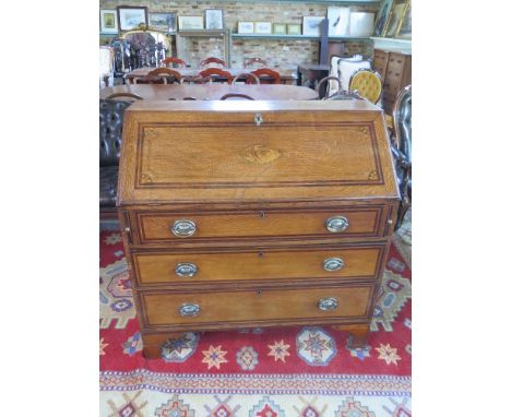 A late 19th century inlaid fall front bureau, fall over three long drawers, inlaid interior raised on bracket supports 
