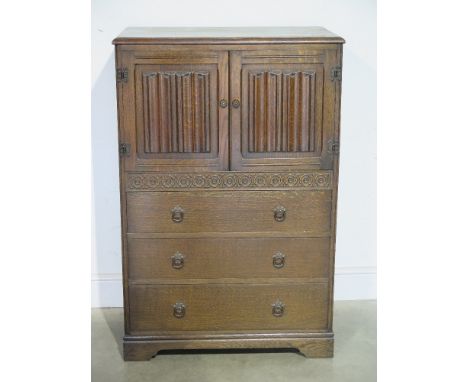 An Old Charm style stained oak chest of two doors over three drawers raised on bracket supports - 78 cm x 47 cn x 118 cm