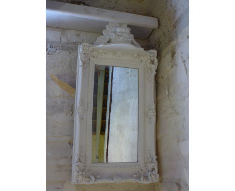 A modern white carved surround mirror with bevelled plate and shelf below - 33cm x 65cm