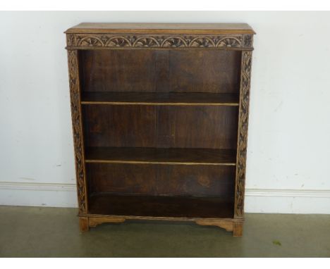 An Edwardian oak open bookcase, carved surround with two shelves to interior raised on bracket supports - 90 cm x 27 cm x 109