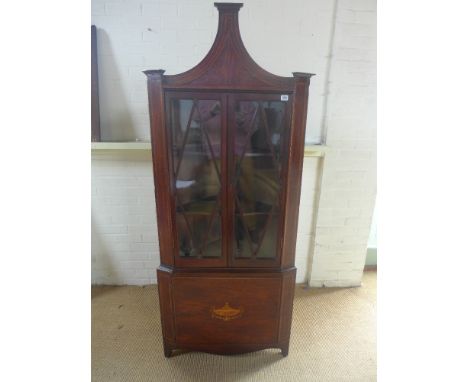 A 19th century mahogany and inlaid corner cupboard twin sectionally glazed doors with shaped shelves to interior over single 