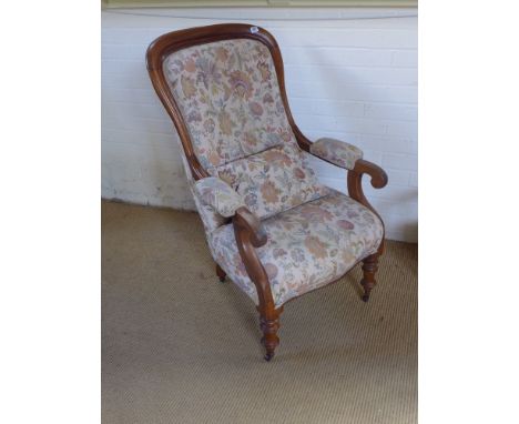 A Victorian mahogany framed spoon back chair button back with floral upholstery pad arms raised on turned supports terminatin