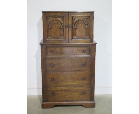 An Old Charm style stained oak tallboy of two doors over four long drawers raised on bracket supports - 79 cm x 46 cm x 139 c
