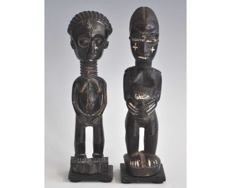 A pair of ancesestor figures, carved as a male and female in standing pose, finished in natural palm oil heightened with whit